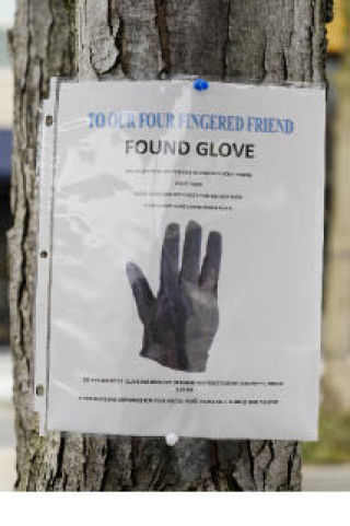 A sign offering to return a custom-made four-fingered glove was posted on a tree near the corner of 78th Avenue S.E. and S.E. 27th Street in the downtown business district of Mercer Island