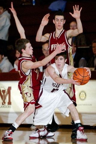 Islander guard Robbie Taylor (15) passes out of a double-team in the final seconds to a teammate for an assist to seal a win against Thomas Jefferson at Mercer Island Wednesday.