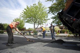 Employees of Adams Asphalt Patching resurface part of the North-end Rite Aid parking lot on Monday
