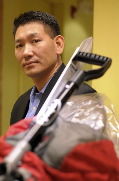 A.C. Sherpa sits with his mountain climbing gear in a dental exam room at his wife's Essence of Dentistry Clinic in Redmond.