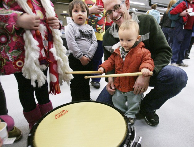 One-year-old Stefan Pallis gets to play a drum belonging to Eastside Fire Pipes and Drums after the group performed at the Firehouse Munch on Friday