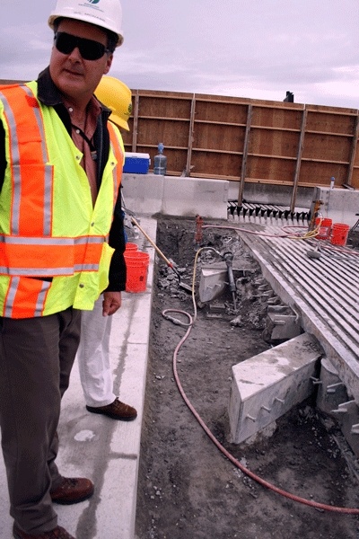 WSDOT spokesperson Gil McNabb shows where crews have jack-hammered out the I-90 floating bridge expansion joints and await their replacement