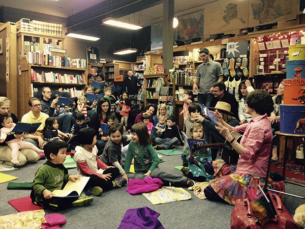 Islander musician Nancy Stewart leads a lively group at Island Books last weekend. Studies have found that young children benefit from music and storytelling.