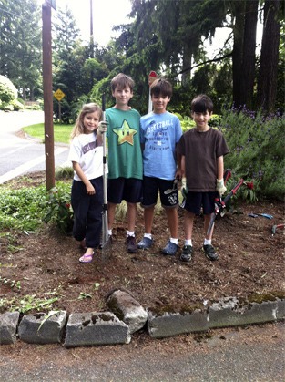 Lakeridge Elementary students participating in the Giraffe Club program spruce up the corner of Island Crest and S.E. 78th Street last month. From left to right