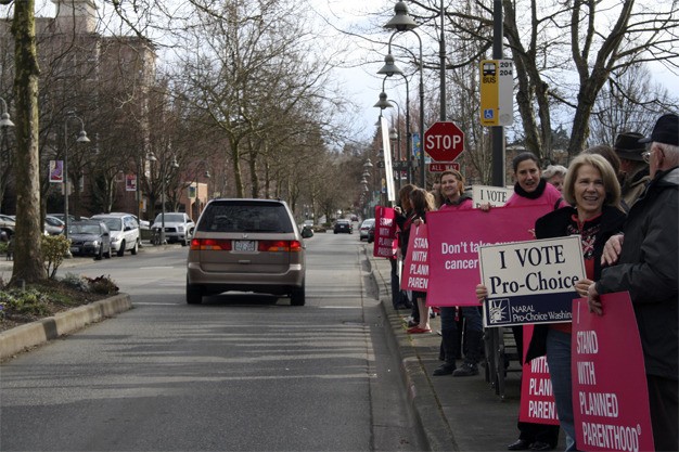 Protestors gathered outside Congressman Dave Reichert's Mercer Island office on March 24. They are concerned that Reichert's voting record is jeopardizing women's health.