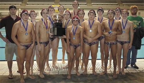 The Mercer Island High School boys water polo team shows off the state trophy after winning its 10th consecutive state title last weekend.