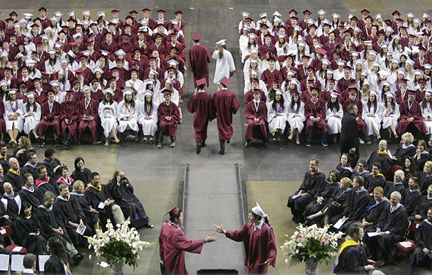 Faculty and students watch as one of three rounds of diplomas are handed out at Key Arena on Thursday.