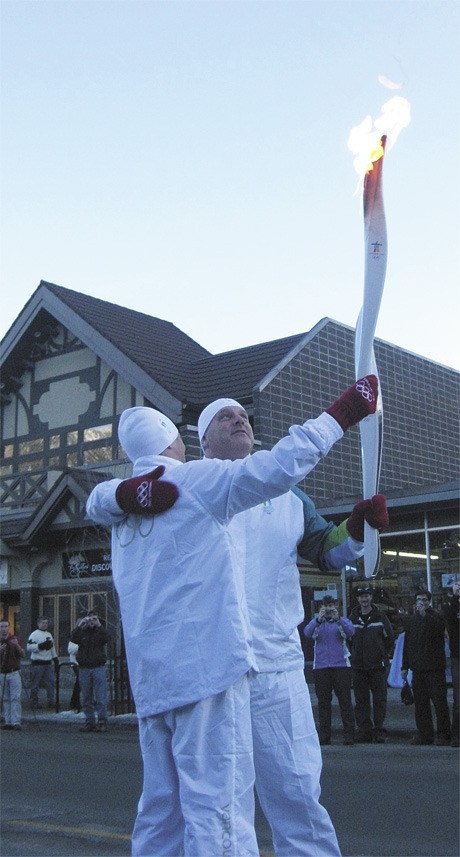 Steve Penny receives the Olympic flame from John Epstein