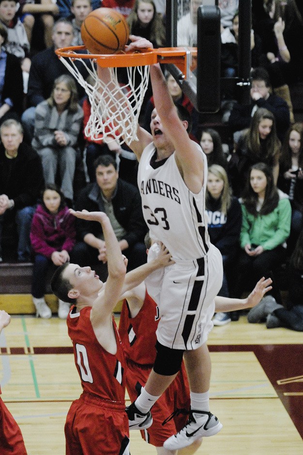 Islander forward Brian Miller (33) dunks over a Rebel defender against Juanita at Mercer Island.