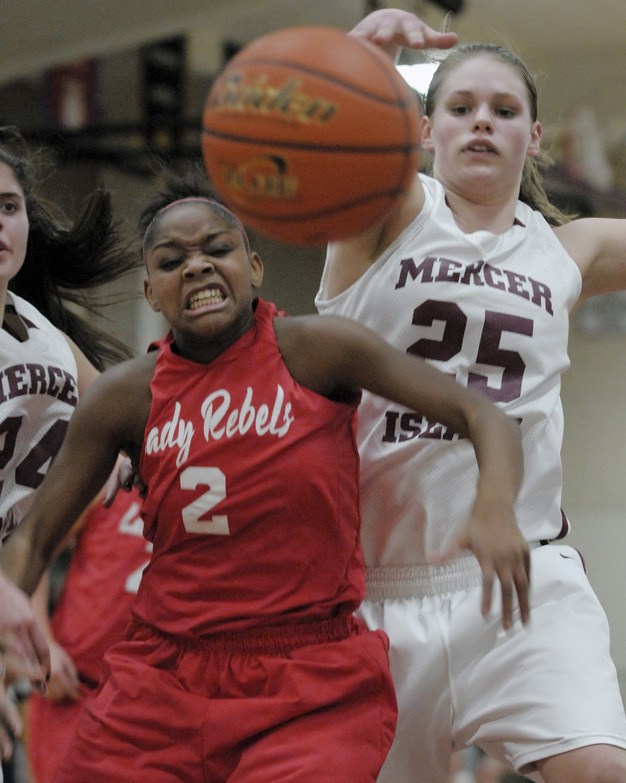 Juanita’s Mikayla Jones (2) holds back Christina Williamson (25) during the Islanders’ home loss to the Rebels on Friday.