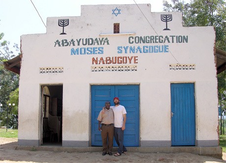 Gabriel Bass stands outside the Abayudaya Moses Synagogue with Rabbi Gershom in Nabugoye Hill