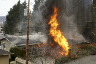 A house engulfed in flames in the 3000 block of 68th Avenue S.E. on Mercer Island on Sunday.