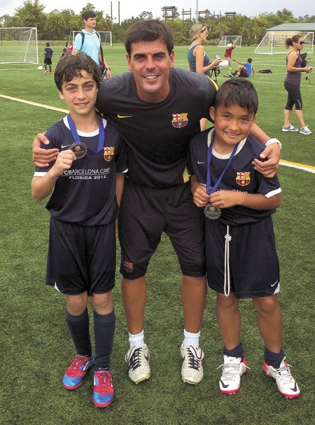 Mercer Island students Emjay Byers and Luca Mtskhetadze with their Barcelona FC coach
