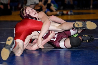 Islander Blake Johnson works his opponent during the Sea-King District wrestling championship tournament at West Seattle High School on Saturday. Johnson won the match by scoring the first point in overtime against his opponent.
