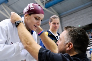 Islanders Rachel Godfred receives her first place medal in the 200-yard individual medley from coach Jeff Lowell during the 3A state swim championships at the King County Aquatic Center in Federal Way