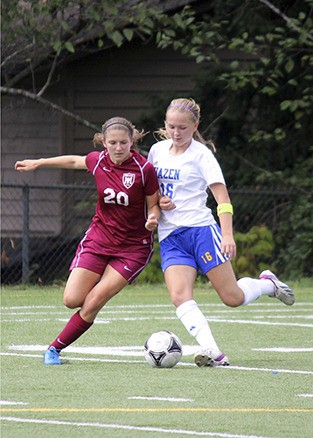 Girls soccer co-captain Katie Rorem is stride-for-stride with her Hazen High School opponent.