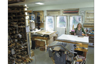 Island resident Mary Chalker poses in her detached ADU custom framing workshop in the First Hill neighborhood of Mercer Island