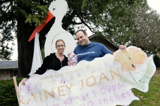 New parents Jenn and Greg Rosenwald hold infant daughter