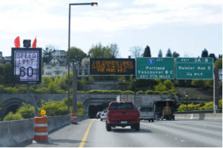 Vehicles traveling westbound across the Interstate 90 floating bridge pass new variable speed limit signs near Mercer Island on Thursday