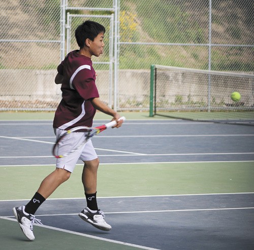 Mercer Island's Brian Hou returns a volley during his first SeaKing district tournament match on Tuesday