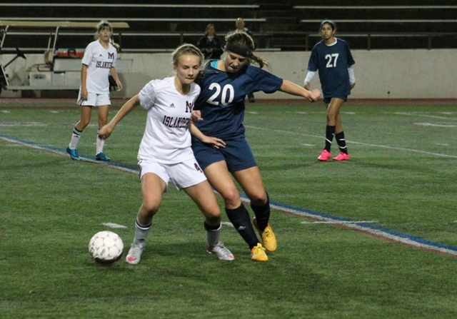 Mercer Island's Jackie Stenberg fights for possession with Bellevue's Carly Tudor Thursday night at Islander Stadium. The Wolverines beat the Islanders 1-0 to win the 3A/2A KingCo league title.