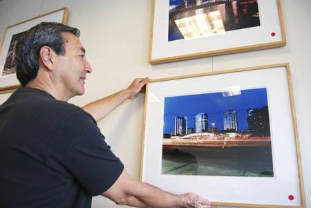 Ken Claflin adjusts a photograph in his exhibit at the Mercer Island Chamber of Commerce.