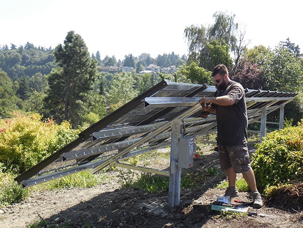 Derek Rice of Artisan Electric puts the final touches on the new solar array at the MICEC on Friday