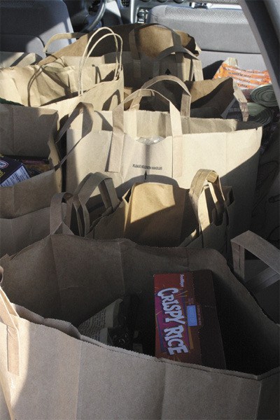 Bags of food destined for the Mercer Island Food Pantry fill the back of Bob Still's car on Wednesday morning