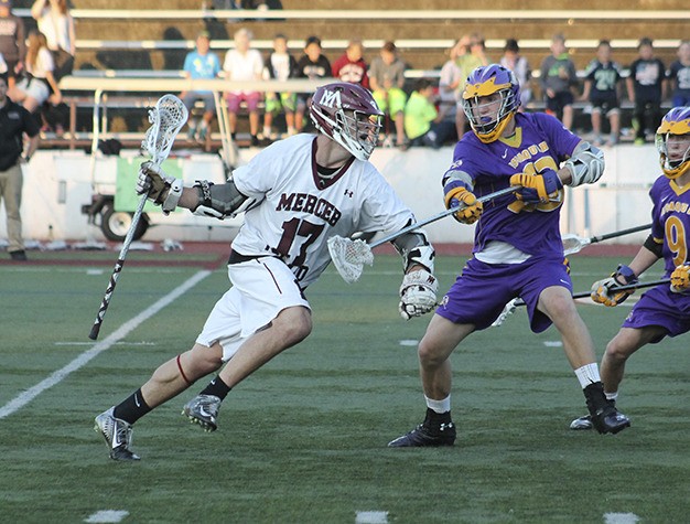 Mercer Island's Evan Condon charges past Issaquah's Spencer Webb during the Div. I boys lacrosse state tournament semifinal Wednesday night at MIHS. The Islanders beat Issaquah 11-10 to advance to the state title game.