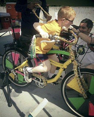 A boy pedals his own drink at the Pedal Smoothies farmers market booth.