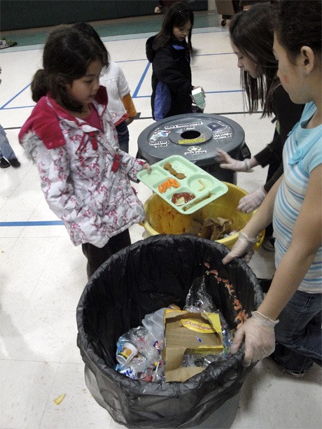 Student volunteers direct diners as to where to put food scraps for composting after lunch at Lakeridge Elementary School.