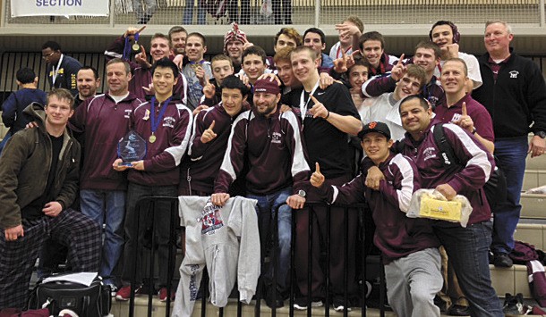 The Mercer Island wrestling team celebrates after winning the KingCo championship on Saturday