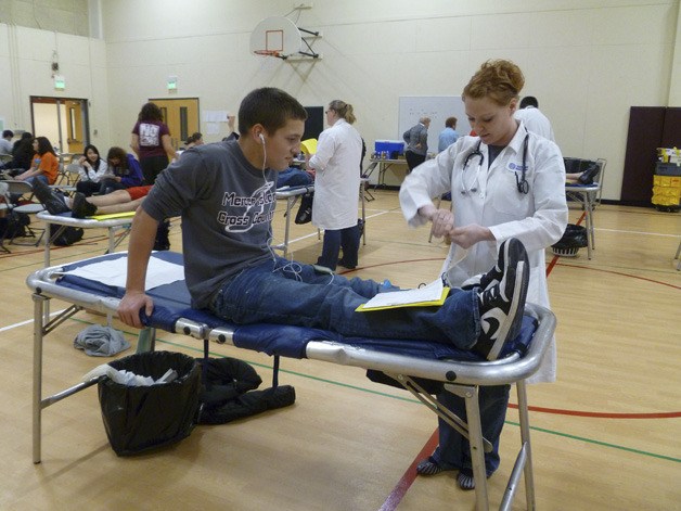 Mercer Island High School junior Vito Giampapa gets prepped to donate blood at a Mercer Island High School gym last Friday afternoon.