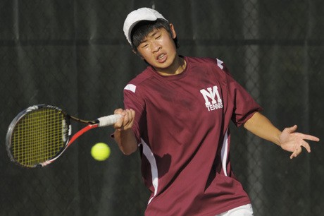 Islander Jeremy Chow returns a serve during boys tennis match play against Bellevue at Mercer Island on Tuesday