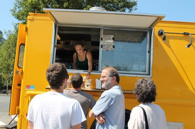 Sam Pierce serves lunch from the Hallava Falafel food truck next to Terra Bella on Thursday