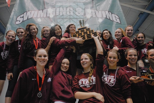 The Mercer Island girls swim team raises the championship trophy at the WIAA 3A state swim and dive meet at the King County Aquatic Center in Federal Way on Saturday.