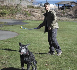 Warren Libman prepares to throw a ball for his dog