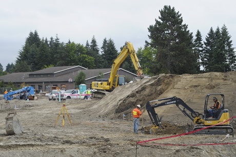 Construction workers are making headway at the PEAK building site on 86th Avenue S.E. The Crest Learning Center is visible in the background.