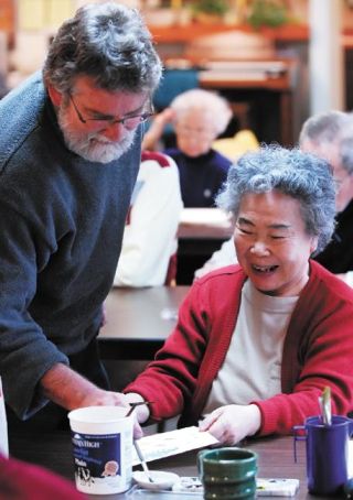 Chad Coleman/Mercer Island Reporter Ellsworth House resident Shuyi Wang shares a laugh with art instructor Bruce Edwards during a painting class Wednesday.