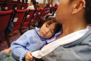 Elizabeth Celms/Mercer Island Reporter Four-year-old Anita Rungsigul cozies up against her father while he listens to Pastor Laohaprasit speak at Sunday’s service.