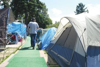 Chad Coleman/Mercer Island Reporter A resident walks between the tents at Tent City 4