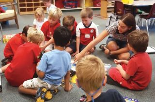 Chad Coleman/Mercer Island Reporter Para-educator Anna Morzinski works with kindergarten students in Marcelle Waldman’s classroom at Lakeridge Elementary School last Friday. Along with paid paraprofessionals