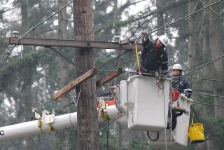Chad Coleman/Mercer Island Reporter A utility repair crew from Southern California Edison works from a bucket lift on the powerlines at the intersection of S.E. 68th Street and Island Crest Way on the South end of Mercer Island Tuesday.