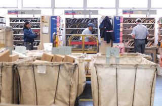 Chad Coleman/Mercer Island Reporter United States Postal carriers sort mail for their routes at the post office on Mercer Island