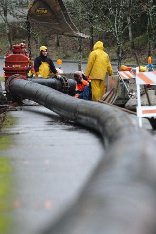 Chad Coleman/Mercer Island Reporter King County crews finish placing a sewage bypass pipe above ground near the Community Center at Mercer View so that they can repair the underground line along North Mercer Way and S.E. 24th Street. The 40-year-old pipe failed during the recent rain storms and caused part of S.E. 24th Street to buckle. The pipe is one of the Island’s main wastewater pipes that connects with the county sewage line that goes under the lake and connects on the Eastside with pipes to the Renton sewage treatment plant. For more details
