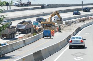 Chad Coleman/Mercer Island Reporter A car merges onto the approach to the I-90 bridge on the west side of Mercer Island as construction continues in order to add new HOV lanes.