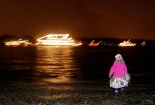 Elizabeth Celms/Mercer Island Reporter A determined little girl wades into Lake Washington for a better view of the Christmas Ships