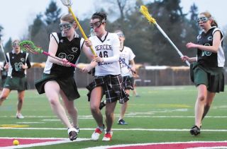 Chad Coleman/Mercer Island Reporter Mallory Larson and two Forest Ridge defenders battle for control of a loose ball during the Islander’s 8-6 victory Friday at Islander Stadium.