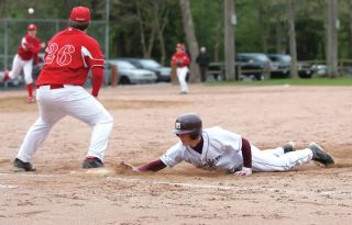 Chad Coleman/Mercer Island Reporter Islander Chris Black dives back to the first-base bag during a 15-7 loss to Newport Wednesday.