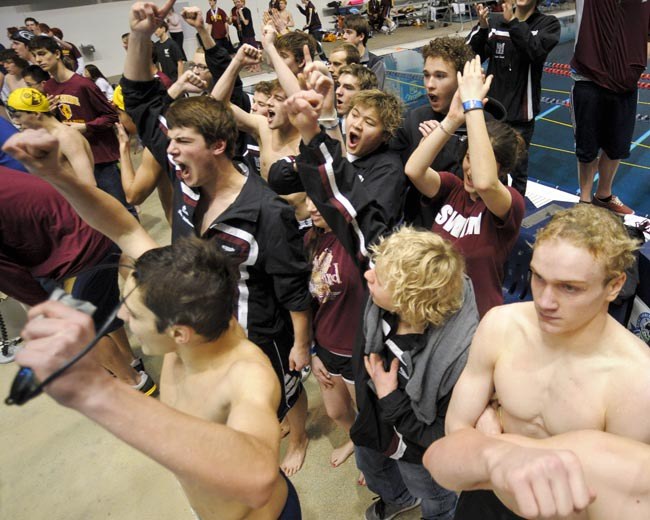 Islander athletes and fans cheer at the 3A state swim final of the 400-yard freestyle relay event at the King County Aquatic Center in Federal Way on Saturday.